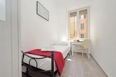 a bedroom with a bed and a table and a window at 4BNB - Cavalleggeri Apartment in Rome