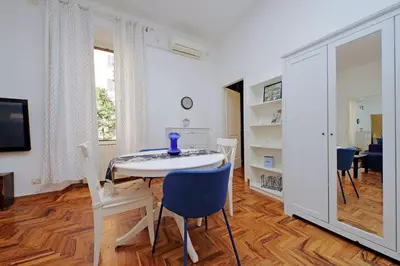 a dining room with a white table and chairs at 4BNB - Lante Apartment in Rome