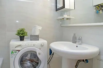 a bathroom with a washing machine and a sink at 4BNB - Lante Apartment in Rome