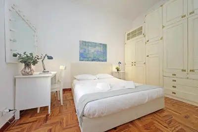 a white bedroom with a bed and a desk at 4BNB - Lante Apartment in Rome