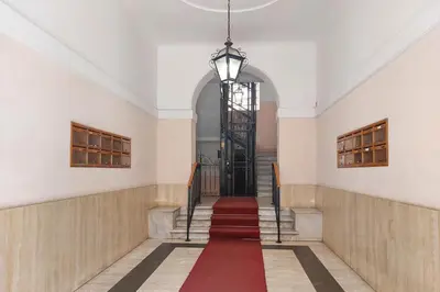 a hallway with a red carpet on the stairs at 4BNB - Lante Apartment in Rome