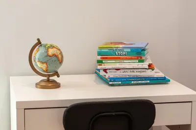 a stack of books sitting on a desk with a globe at Pigneto Holiday in Rome