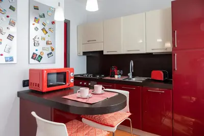 a kitchen with a red microwave and a table with chairs at Pigneto Holiday in Rome