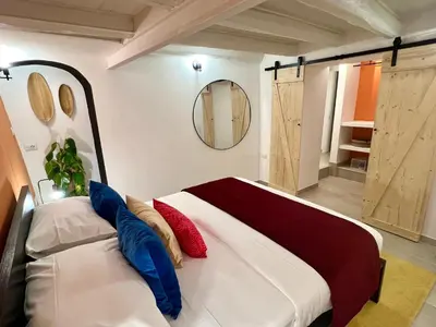 a bedroom with a large bed with red and blue pillows at Charming Navona - The Loft in Rome