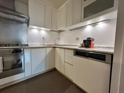 a kitchen with white cabinets and a stove top oven at Elegant 3 bedrooms apartment Colosseum - San Giovanni in Rome