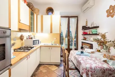 a kitchen with white cabinets and a table and a dining room at Appartamento elegante Castel Sant'Angelo in Rome
