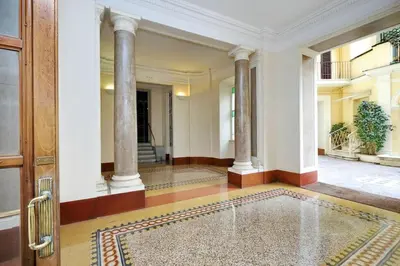an empty hallway with columns and a door at Appartamento elegante Castel Sant'Angelo in Rome