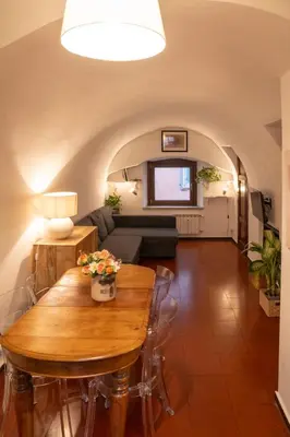a living room with a wooden table and a couch at Arco del Calidarium - Pantheon in Rome