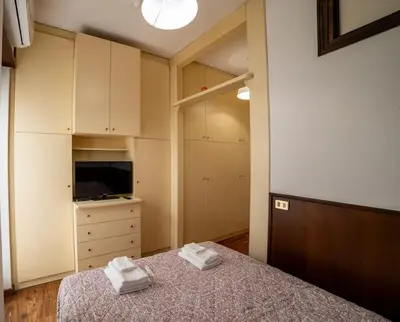 a bedroom with a bed and a dresser with towels at Richard & Lulù in Rome in Rome