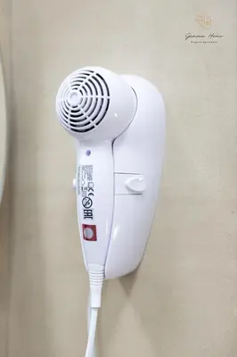 a white hair dryer hanging on a wall at Gemma House - 100mt to Metro Station, 2 En-Suite bathrooms in Rome