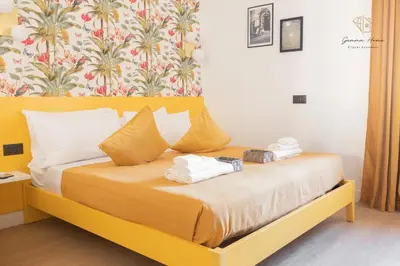 a bedroom with a yellow bed with towels on it at Gemma House - 100mt to Metro Station, 2 En-Suite bathrooms in Rome