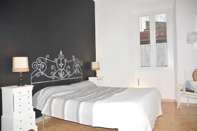 a bedroom with a white bed and a black wall at Cosy Apartment - 5 Minutes Walk from Colosseum in Rome