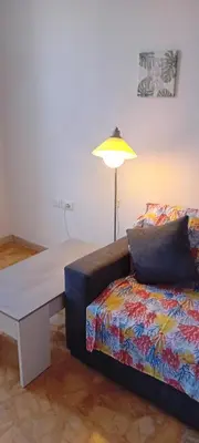 a living room with a couch and a table and a lamp at Cosy Apartment - 5 Minutes Walk from Colosseum in Rome