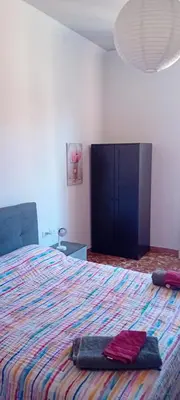 a bedroom with a large bed with a colorful blanket at Cosy Apartment - 5 Minutes Walk from Colosseum in Rome