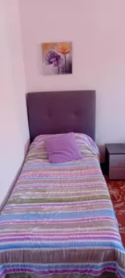 a bed with a purple pillow and a picture on the wall at Cosy Apartment - 5 Minutes Walk from Colosseum in Rome