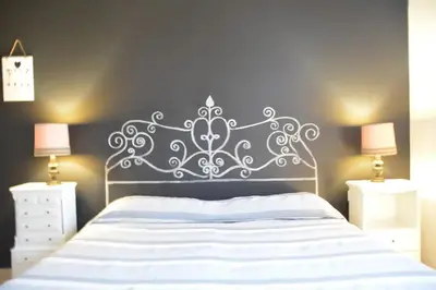 a bedroom with a white bed with a metal headboard at Cosy Apartment - 5 Minutes Walk from Colosseum in Rome