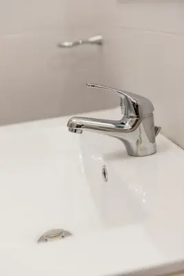 a silver faucet on a white bathroom sink at Appartamento via di Montegiordano in Rome