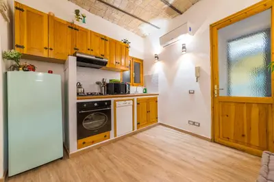 a kitchen with wooden cabinets and a refrigerator at Appartamento via di Montegiordano in Rome