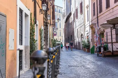 a cobblestone street with people walking down the street at Appartamento via di Montegiordano in Rome