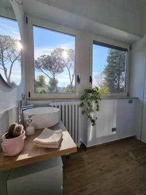 a bathroom with a sink and two windows at Parco della Musica House in Rome