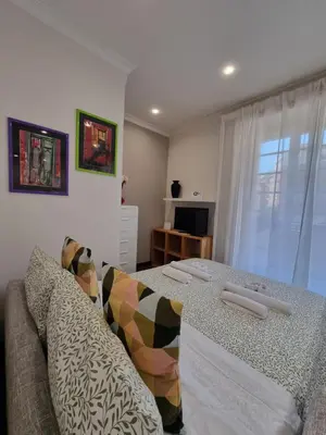 a bedroom with a bed and a couch and a window at Relais Viola at the Vatican in Rome