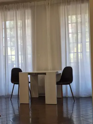 a white table and two chairs in front of windows at Relais Viola at the Vatican in Rome