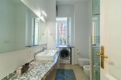 a bathroom with a sink and a washing machine at Casa Barbieri boutique apartment Flaminio in Rome