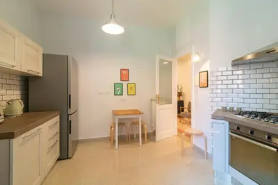 a kitchen with white cabinets and a table in it at Casa Barbieri boutique apartment Flaminio in Rome