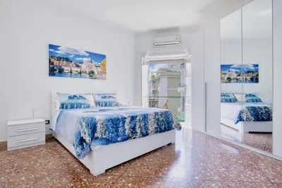 a white bedroom with a bed and a plant at Orti Apartment in Rome