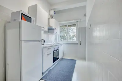 a white bedroom with a large bed and a dresser at Orti Apartment in Rome