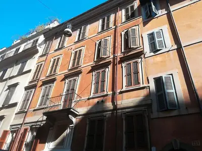 a large building with many windows on a street at Little gem in Trevi Fountain in Rome