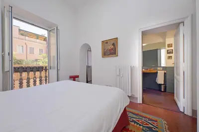 a bedroom with a white bed and a large window at Monti in Rome