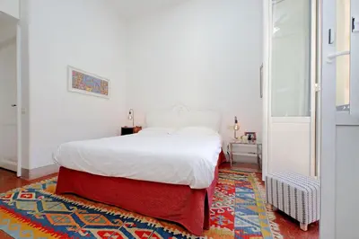 a bedroom with a white bed and a red rug at Monti in Rome