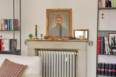 a portrait of a man sitting on top of a fireplace at Monti in Rome