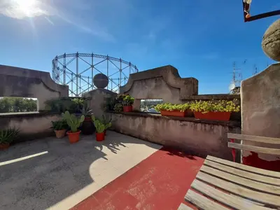 a patio with plants and a ferris wheel in the background at Elena's Apartment - Piramide Metro Station in Rome
