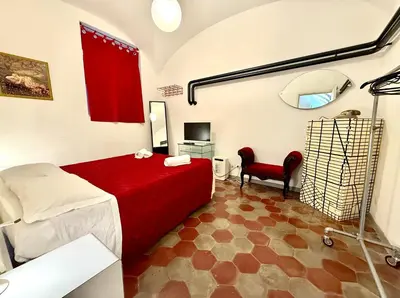 a bedroom with a red bed and a mirror at Garbatella Vintage in Rome