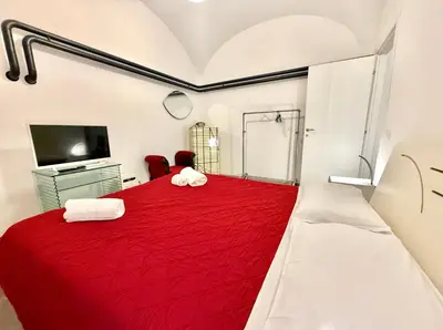 a bedroom with a red bed and a tv at Garbatella Vintage in Rome