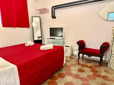 a bedroom with a red bed and a red chair at Garbatella Vintage in Rome