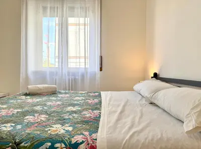 a bedroom with a bed with a floral bedspread and a window at 10 minuti da stazione Trastevere in Rome