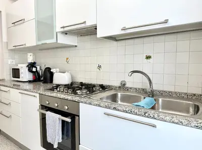 a white kitchen with a sink and a stove at 10 minuti da stazione Trastevere in Rome