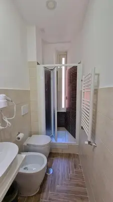 a white bathroom with a toilet and a shower at Susy's Guest House - Room Spagna in Rome