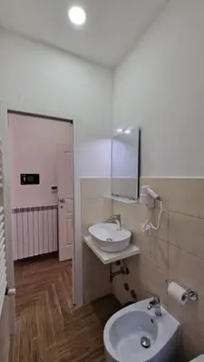 a bathroom with a sink and a toilet and a mirror at Susy's Guest House - Room Spagna in Rome