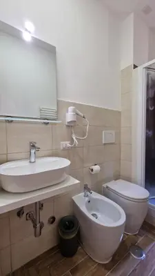 a bathroom with a sink and a toilet and a mirror at Susy's Guest House - Room Spagna in Rome