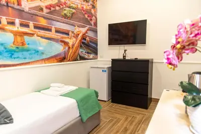 a bedroom with a bed and a tv at Susy's Guest House - Room Spagna in Rome