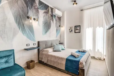 a bedroom with a bed and a chair at Napolehome Luxury Apartment in Rome
