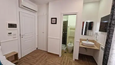 a white bathroom with a sink and a mirror at Susy's Guest House - Room Trevi in Rome
