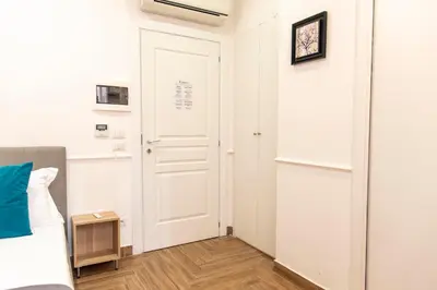 a bedroom with a white door and a wooden floor at Susy's Guest House - Room Trevi in Rome