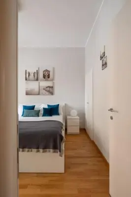 a white bedroom with a bed with blue pillows at New apartment near Piazza del Popolo in Rome