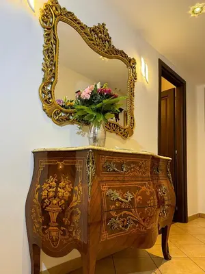 a dresser with a mirror and a vase with flowers on it at Romeantique in Zama in Rome