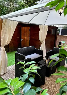 a patio with two chairs and an umbrella at Romeantique in Zama in Rome